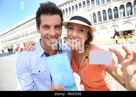 Couple de touristes Cherful montrant carte de visiteur Banque D'Images