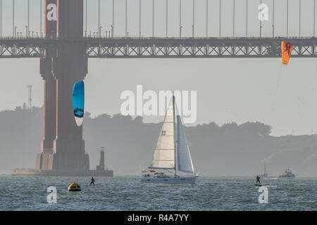 Deux kitesurfers et un voilier sous le golden gate bridge dans la baie de San Francisco. Banque D'Images