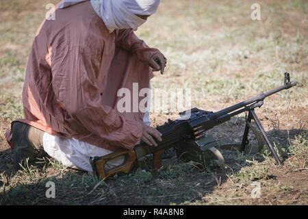 SAMBEK, région de Rostov, en Russie, le 19 août 2018 : Reconstruction de la guerre afghane. Soldat voilée est assis sur le sol à proximité de la mitrailleuse Banque D'Images