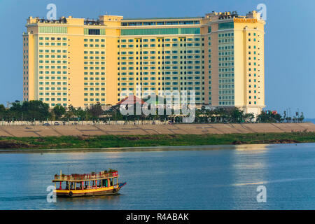 Bateau de croisière au coucher du soleil & Sokha hotel au confluent du Tonlé Sap et les rivières du Mékong ; Central Riverfront, Phnom Penh, Cambodge Banque D'Images