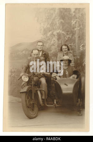 Studio portrait postcard / carte de voeux d'heureux vacanciers posant sur une moto et side-car prop, atelier de Charles Howell, Blackpool, Lancashire, Royaume-Uni 1937 Banque D'Images