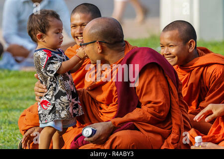 Les moines bouddhistes avec de jeunes enfants dans le Palais Royal Park. Preah Sisowath Quay, centre-ville, Phnom Penh, Cambodge Banque D'Images