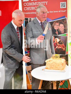 Le prince de Galles coupe un gâteau d'anniversaire avec le pasteur Roger Frapwell dans l'église communautaire de Dorchester, Poundbury, Dorset, où le prince ouvre l'église et le nouveau développement de logements Extra Care du groupe de logement de Yarlington. Banque D'Images