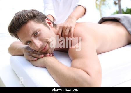 Bel homme allongé sur un lit de massage Banque D'Images