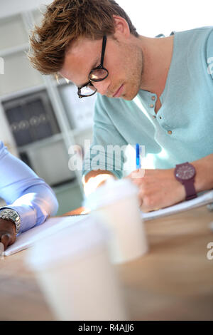 Portrait de jeune homme en remplissant le formulaire de demande Banque D'Images