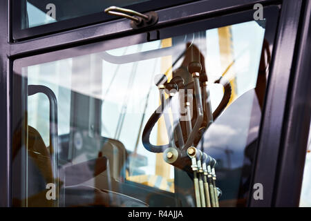 Le volant et les leviers dans le cockpit du motor grader Banque D'Images