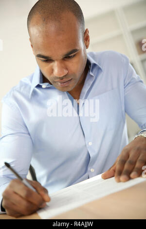 Jeune homme écrit sur papier Banque D'Images