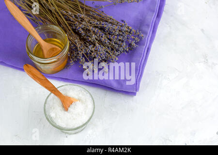 Vue de dessus les fleurs de lavande à sec, miel, sel de mer, un spa situé sur l'arrière-plan blanc béton miteux Banque D'Images