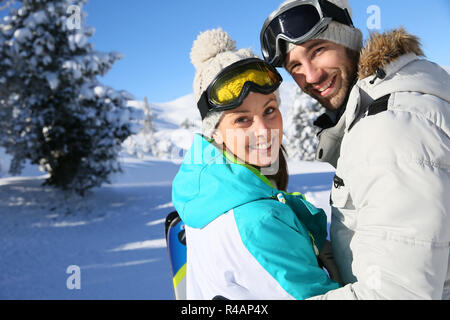 Cheerful couple standing in snowy mountain Banque D'Images