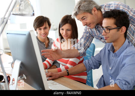 Avec les élèves de l'enseignant sur le bureau de travail Banque D'Images