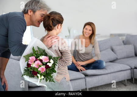 Jeune fille offrant des fleurs à sa maman Banque D'Images