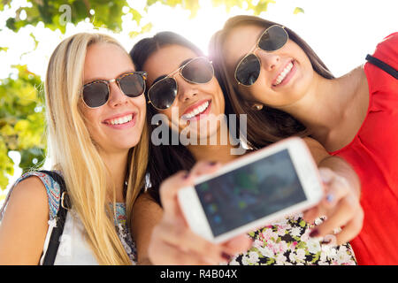 Trois amis à prendre des photos avec un smartphone Banque D'Images