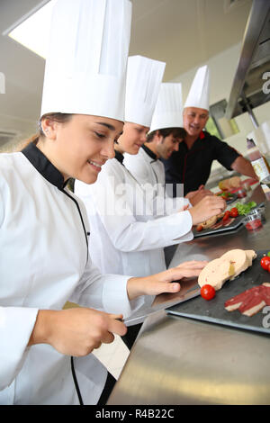 Équipe de jeunes cuisiniers préparer les plats traiteur Banque D'Images