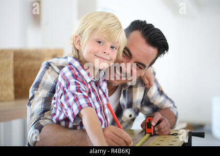 Père avec mesure de la planche en bois pour enfants Banque D'Images
