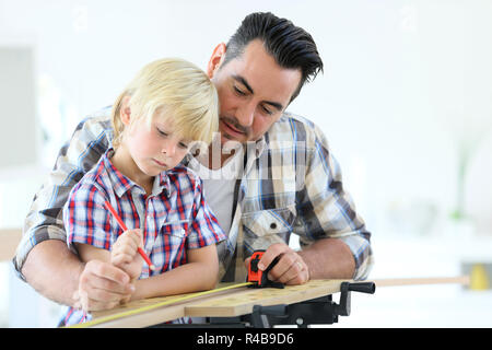 Père avec mesure de la planche en bois pour enfants Banque D'Images