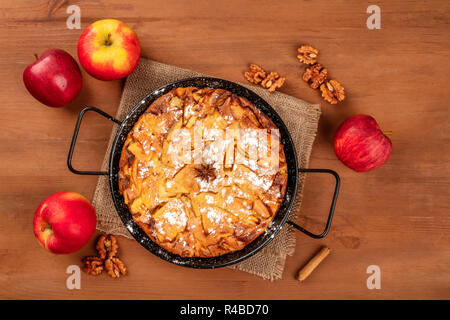 Une photo d'une tarte aux pommes dans une casserole, tourné par le haut sur un fond de bois rustique foncé avec les pommes, les noix, la cannelle, l'anis, et copy space Banque D'Images