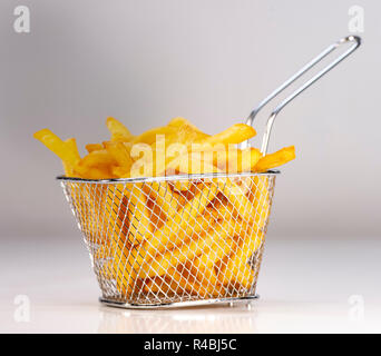 Panier de frites fraîchement faite sur fond studio blanc Banque D'Images