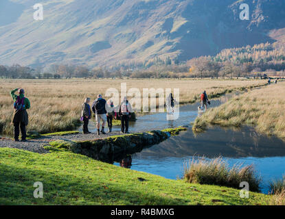 Groupe de randonneurs pagayer à travers un sentier inondé dans le Lake District Angleterre Royaume-uni. Banque D'Images