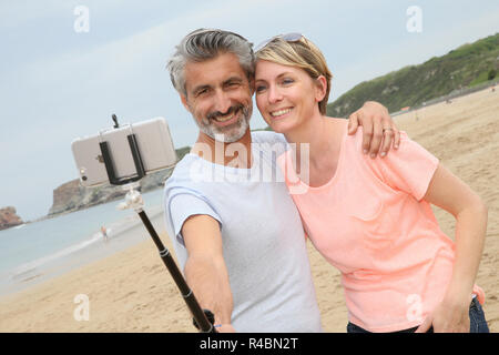 Couple taking photo avec le smartphone et monopode extensible Banque D'Images