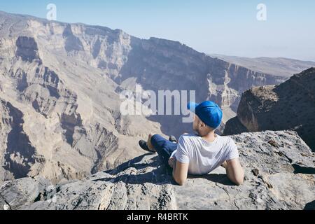 Les jeunes au repos touristique sur le bord de la falaise. Le Jebel Akhdar, Grand Canyon d'Oman. Banque D'Images