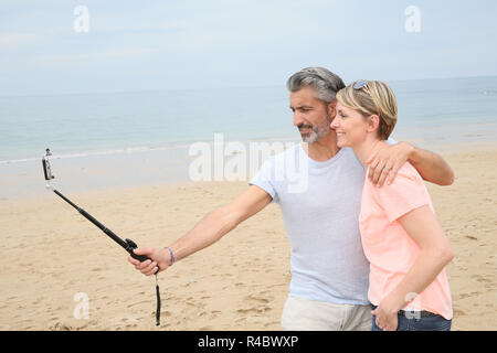 Couple taking photo avec le smartphone et monopode extensible Banque D'Images