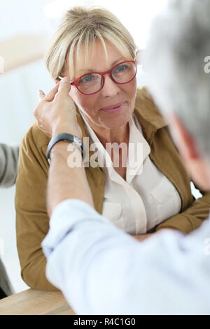 Hauts femme essayant de nouvelles lunettes, magasin optique sur Banque D'Images