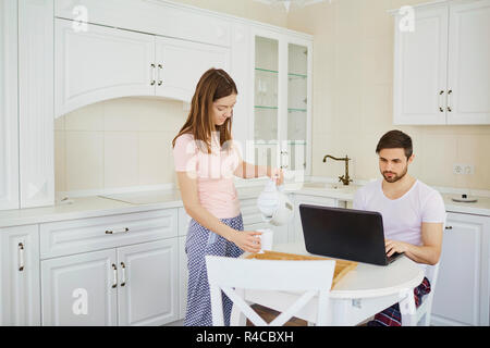 Un jeune couple est le petit-déjeuner à la table de travail, avec un Banque D'Images