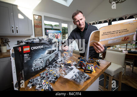 Homme d'âge moyen à la maison lego construction en Angleterre, comme les adultes, sont l'admission à la dépendance à l'édifice en brique de phénomène, Royaume-Uni. Banque D'Images