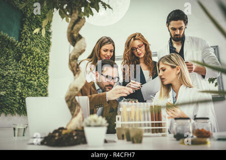 Les biologistes de l'université collègue prenant l'expérience de graines et de contrôle de l'analyse de l'échantillon de l'usine. Banque D'Images