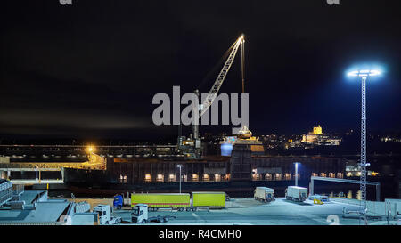 Benne hydraulique mécanique agrippeurs chargement de charbon sur le navire pendant la nuit. Banque D'Images