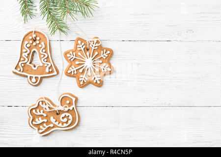 Gingerbread cookies de Noël sont accrochés sur la direction générale de l'épinette blanche sur fond de bois avec l'exemplaire de l'espace. Décorations faites à la main. Banque D'Images