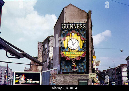 Publicité Guinness et de l'horloge sur le côté d'Irwin Frères Watch and Jewellery shop qui a ouvert ses portes en 1897 au 22, rue Patrick, (R445), comté de Limerick, Limerick, Irlande. La zone a été régénérée depuis cette image originale prise dans les années 60, mais après avoir regardé sur Google maps la boutique ressemble maintenant fermé. Banque D'Images