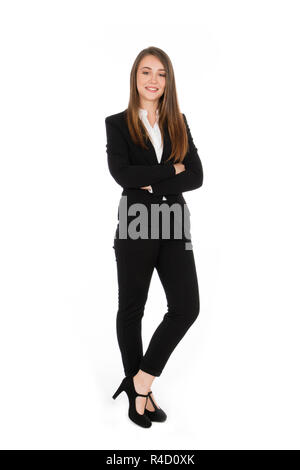 Smiling girl with long hair, elle est debout avec les bras croisés, vêtu d'un costume noir et chemise blanche et des chaussures à talons hauts Banque D'Images