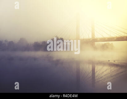 Brouillard recouvre river et Bridge au lever du soleil Banque D'Images