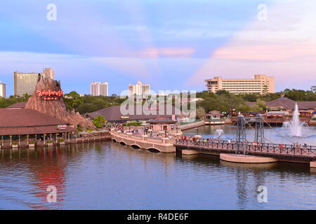 Orlando, Floride. 15 novembre 2018 Vue panoramique de volcan, vintage bridge et hôtels sur le coucher du soleil avec rayons magenta de Lake Buena Vista Banque D'Images