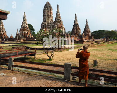 Le moine bouddhiste de prendre une photo de Wat Chaiwatthanaram avec un smartphone Banque D'Images