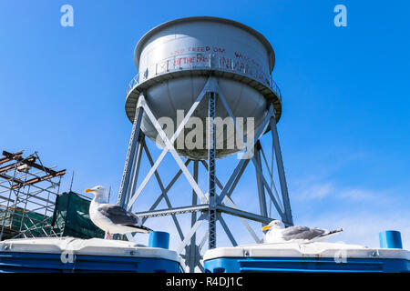 Tour de l'eau sur le dessus de la colline verte, rétroéclairé par Sun contre le ciel bleu, l'île d'Alcatraz Banque D'Images