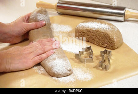 Mains préparer la pâte pour le dessert de Noël sur table de cuisine avec moules et pour la pâte de roulement à rouleaux Banque D'Images