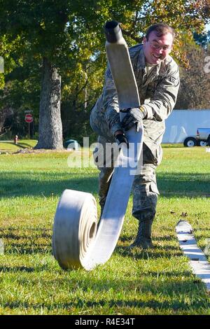 Les cadres supérieurs de l'US Air Force Airman Matt Hargis, 633e Escadron de génie civil en systèmes aéronautiques électriques, jette une lance à incendie dans une tentative de renverser les bouteilles, au cours d'une force d'urgence de l'ingénierie de base Premier défi préparation à base Langley-Eustis mixte, en Virginie, le 25 octobre 2016. Hargis, avec d'autres membres de la SCÉ 633e de différentes sections, ont pris part à des événements qui les a défiés à différentes compétences. Banque D'Images