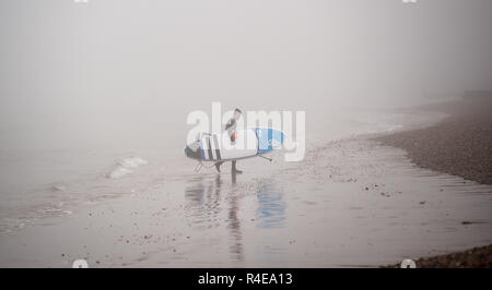 Brighton, UK. 27 Nov, 2018. Une pagaie boarder émerge du brouillard épais sur la plage de Brighton par le West Pier de Brighton ce matin mais plus doux et pluvieux est prévu en Grande-Bretagne au cours des prochains jours de crédit : Simon Dack/Alamy Live News Banque D'Images