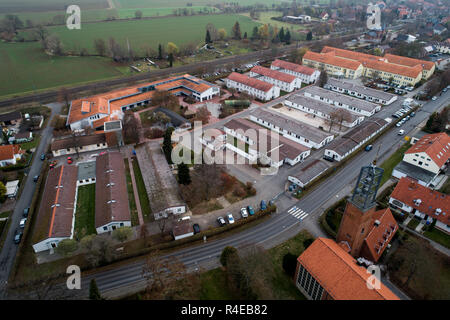 Friedland, de l'Allemagne. 27 Nov, 2018. Aperçu de l'autorité d'enregistrement d'État de Basse-Saxe, Friedland transit frontalier camp site, avec le clocher de l'Église catholique de Saint-Norbert. (Photo aérienne avec un bourdon) ce matin, le cabinet du gouvernement de Basse-Saxe a rencontré dans le camp de transit frontaliers Friedland. Credit : Swen Pförtner/dpa/Alamy Live News Banque D'Images