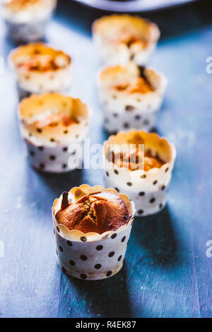 Close up de certains des petits muffins à la citrouille est bordée sur une plaque de cuisson en aluminium pour l'halloween affichées sur un bord, rustique blu télévision jeter dessus,nat Banque D'Images