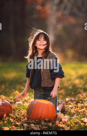 Smiling Girl sculpter une citrouille d'Halloween dans le jardin, United States Banque D'Images