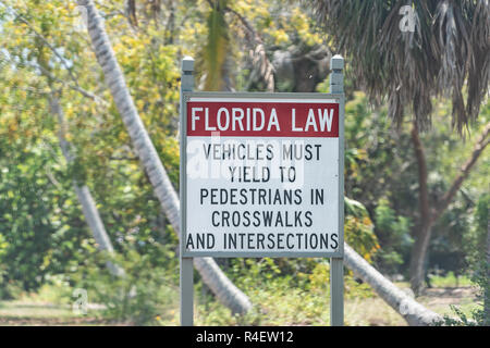 La loi de la Floride signe sur l'île de Sanibel, USA dans le parc par plage près de Fort Myers, Floride Sur route - cédez le passage aux piétons aux passages pour piétons aux intersections et en Banque D'Images