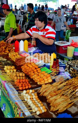 Femme vend des aliments salés frits de la cabine à la nourriture extérieure Section Satok Weekend Market Kuching Malaysia Banque D'Images