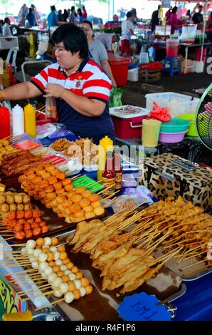 Femme vend des aliments salés frits de la cabine à la nourriture extérieure Section Satok Weekend Market Kuching Malaysia Banque D'Images