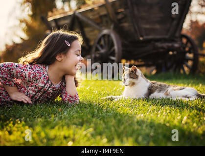 Cute little girl smiling to a fluffy cat Banque D'Images