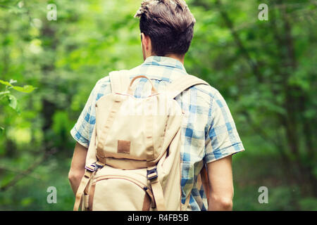 Jeune homme avec backpack hiking in woods Banque D'Images