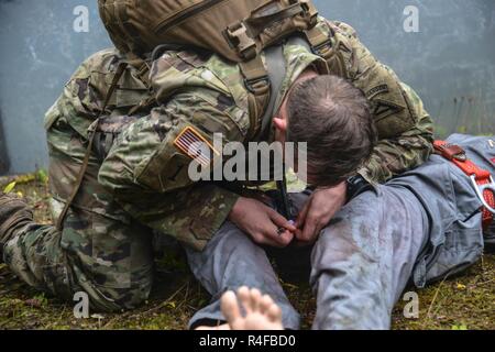 Un soldat américain, affecté au 1er Bataillon, 4e Régiment d'infanterie, s'applique l'aide d'une victime simulée dans le cadre de l'évacuation sanitaire au cours de l'événement l'équipe de Sniper meilleur compétition à la 7e armée du Commandement de l'aire d'entraînement Grafenwoehr Allemagne, le 25 octobre, 2016. L'Escouade Sniper mieux la concurrence est un stimulant de la concurrence l'Europe de l'armée les militaires de toute l'Europe de la concurrence et améliorer le travail d'équipe avec les alliés et les pays partenaires. Banque D'Images