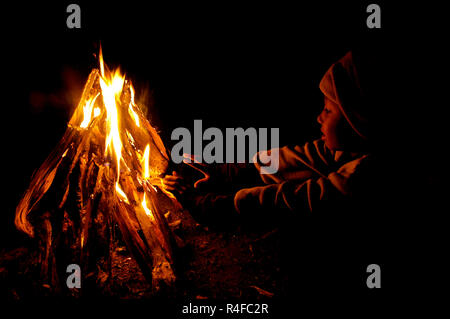 Un garçon de la communauté indigène garo se réchauffe à lui-même le feu dans une nuit d'hiver. Durgapur, Netrokona, au Bangladesh. Banque D'Images